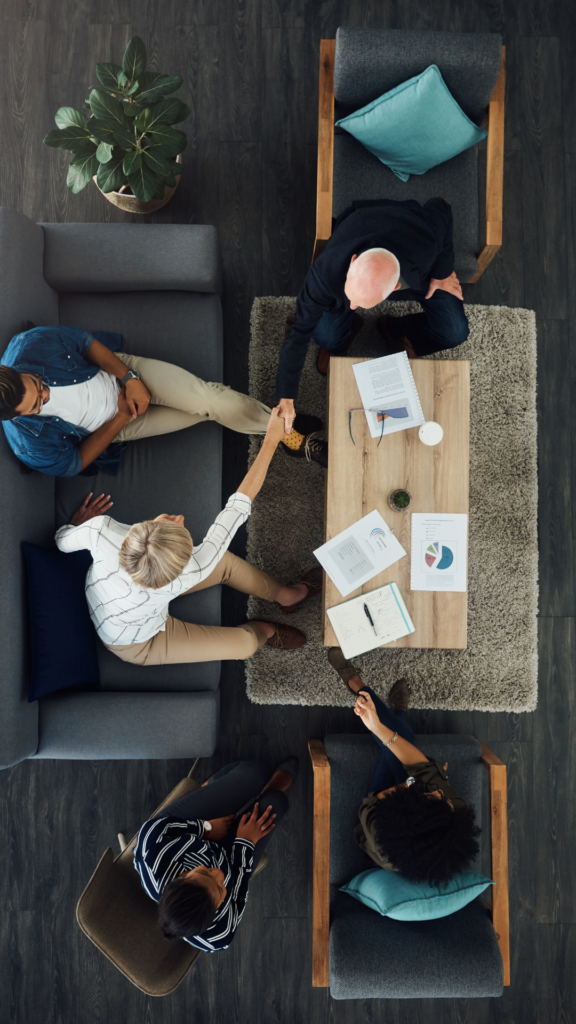 Personne se serrant la main vu de haut sur des divans